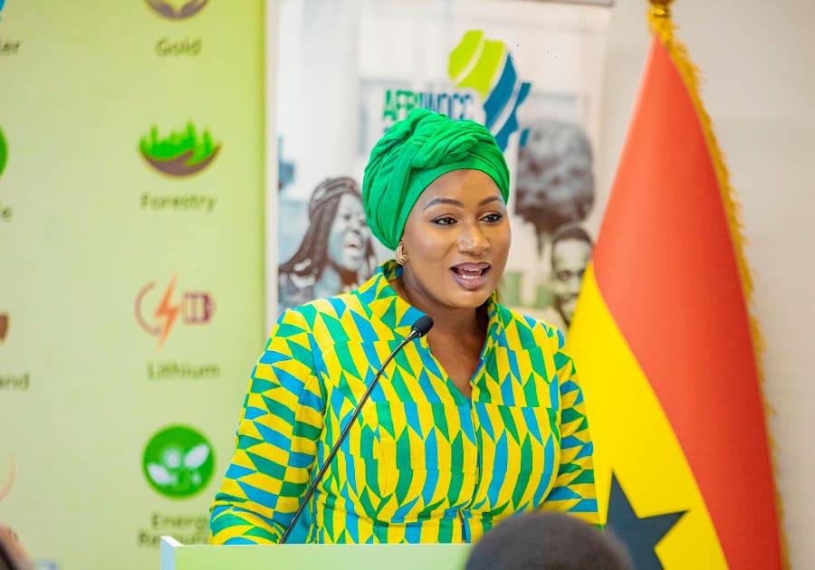 Samira Bawumia, in a green headwrap, speaks at a lectern