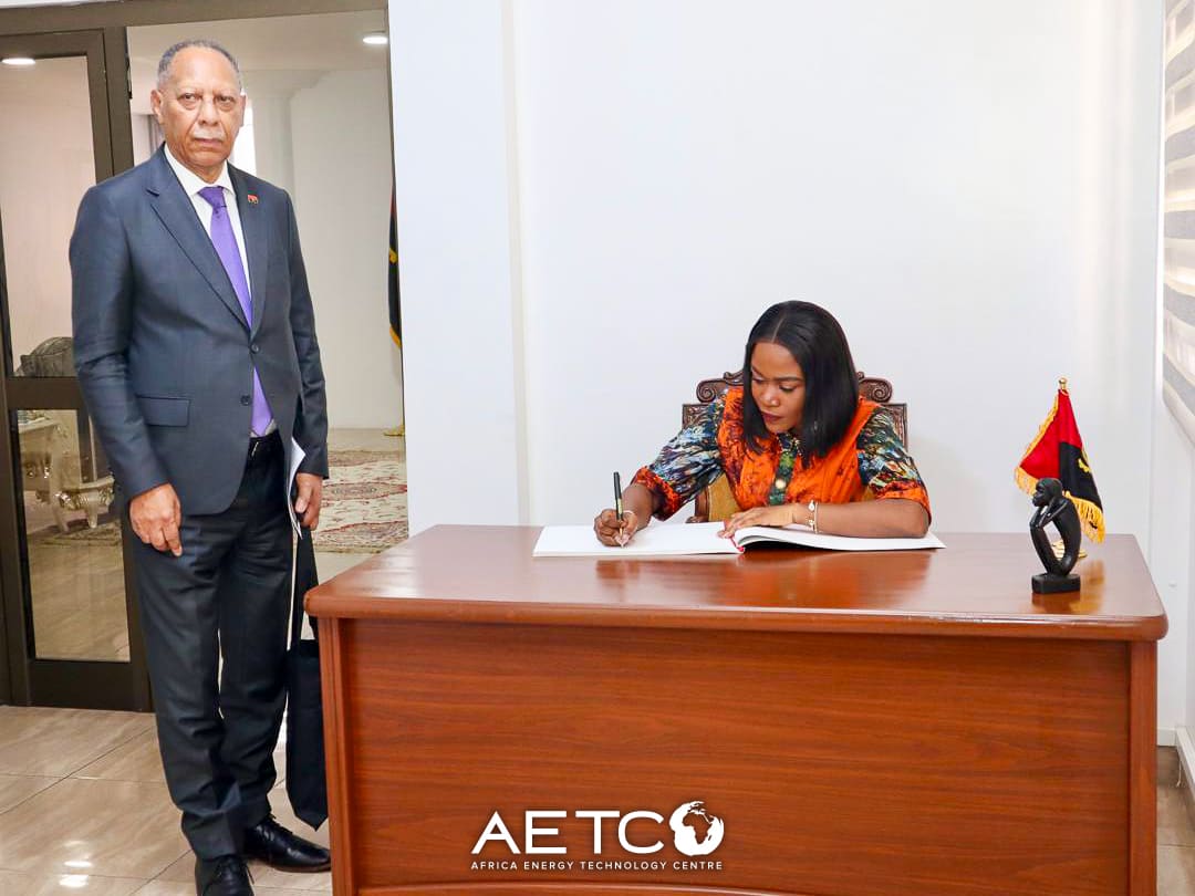 Emelia Akumah signs the guest book at the Embassy of Angola as Ambassador Rui Orlando Xavier looks on