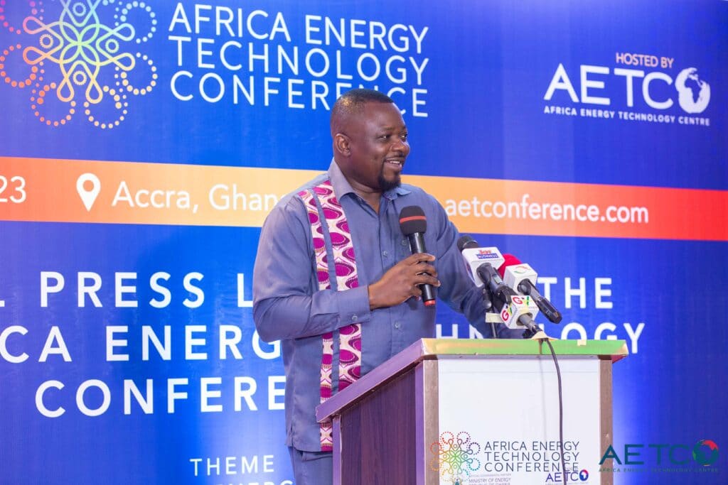 A speaker in a kente stole addresses the room from the lectern at the press launch of the first Africa Energy Technology Conference, Alisa Hotel, Accra, June 2023