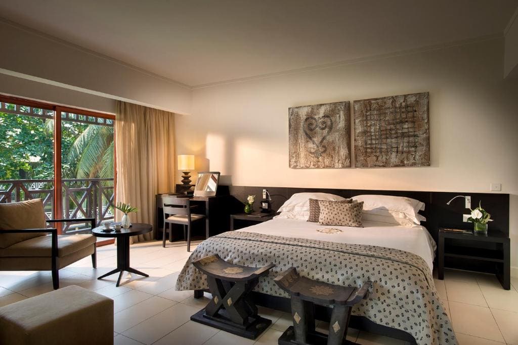 A guest room at Labadi Beach Hotel with Adinkra wall panels and a balcony onto the palms