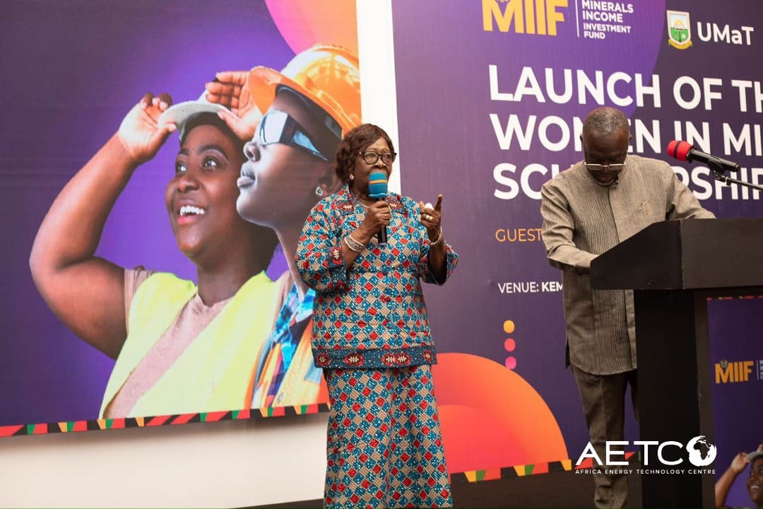 A speaker at the lectern beside the Women in Mining scholarship banner